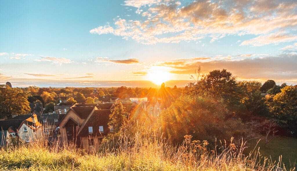 Sun setting over trees and rooftops in Cambridge, one of the city's best sunset viewpoints