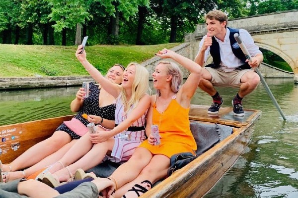 3 women sit at the back of the punt taking a selfie with the chauffeur behind getting in the shot