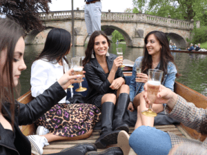 girls having fun, drinkin prosecco on a punt during summer