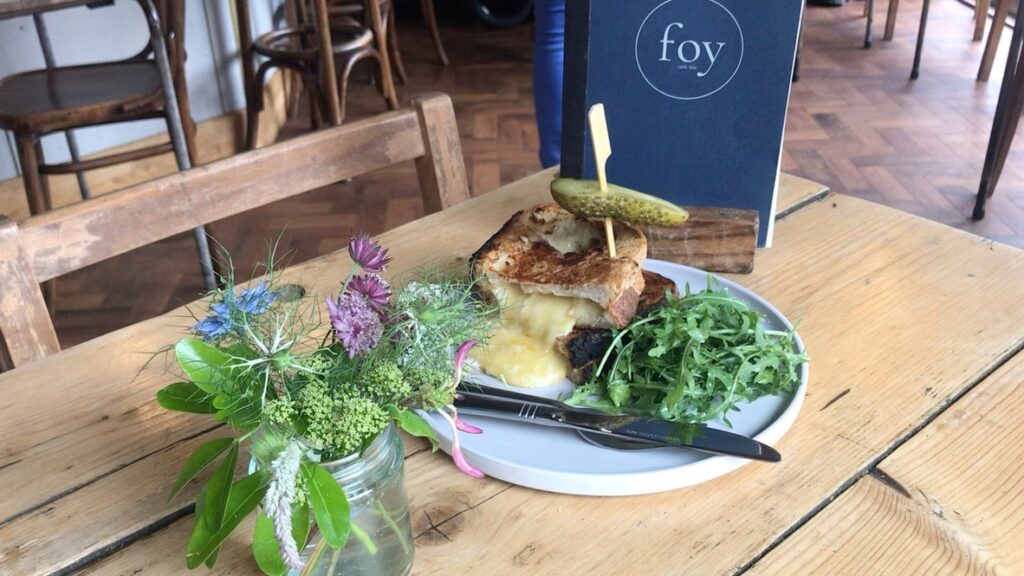 Cafe Foy Cambridge cheese toastie with menu in background and flowers in the foreground