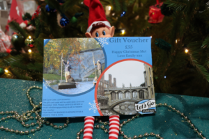 Christmas voucher for punting in Cambridge held by an elf