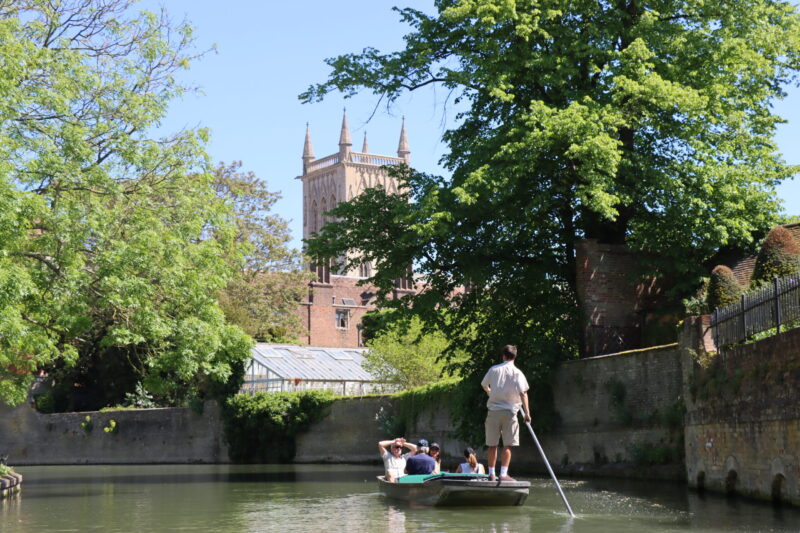 a punting boat on the River Cam with Let's Go Punting with St John's Chapel in the background