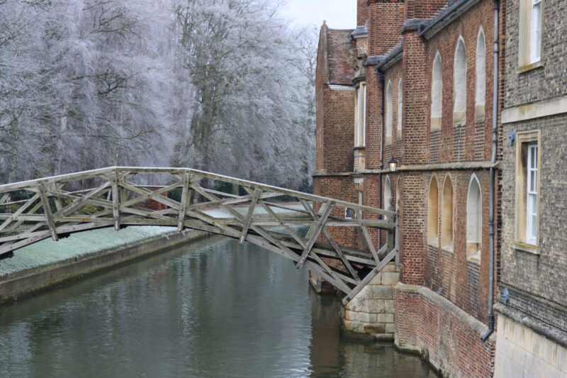 Mathematical Bridge at Queens' College framed by frost-covered trees in winter.
