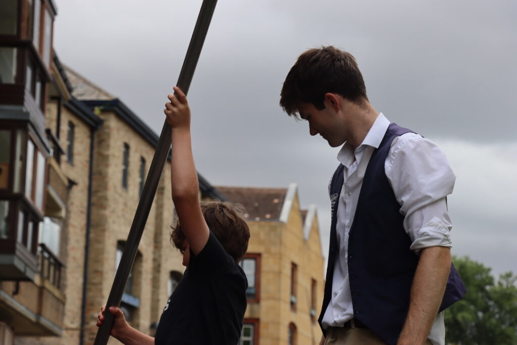a little boy trying punting with the help of a chauffeur at Let's Go Punting