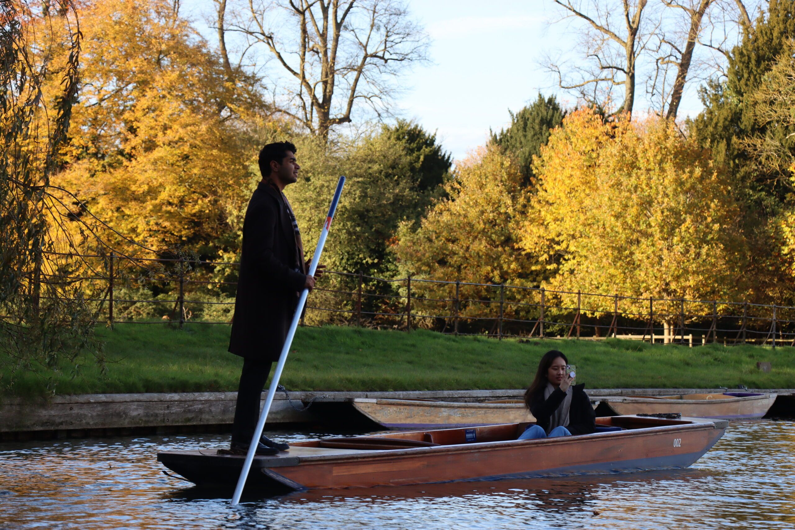 two people on a punting boat self hiring in Cambridge on The Cam