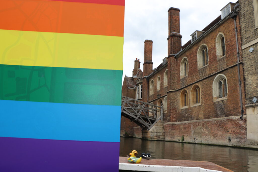 Rainbow Pride stripes alongside Queens' College and the Mathematical Bridge on the River Cam.