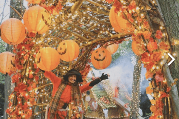 Costumed performer under an archway of pumpkin lanterns at the Audley End Miniature Railway.