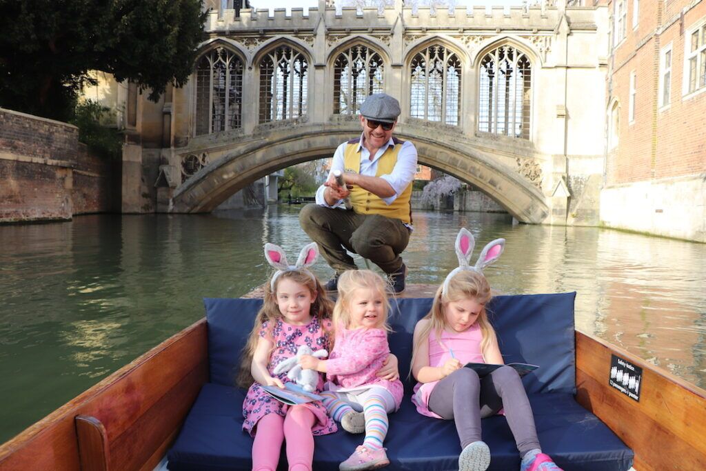 Three girls in bunny ears on an Easter punt tour as the chauffeur steers past the Bridge of Sighs.