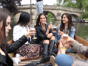 girls having fun, drinkin prosecco on a punt during summer