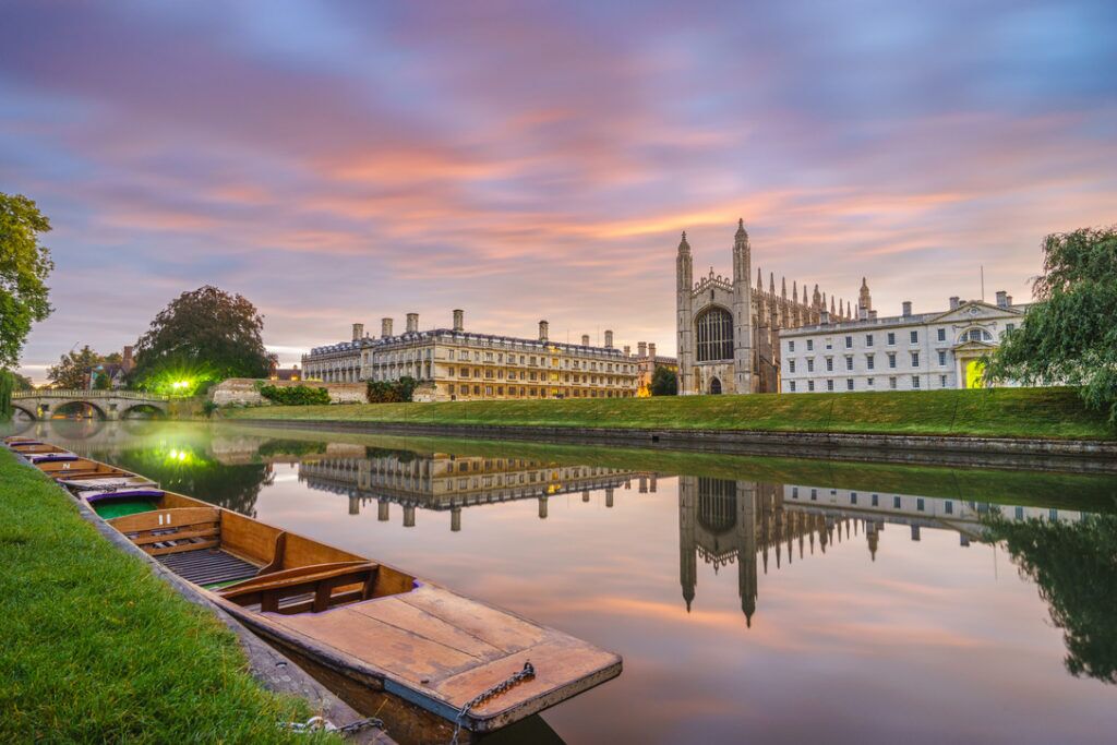 King's College Chapel at sunrise from The Backs with moored punts on the still River Cam