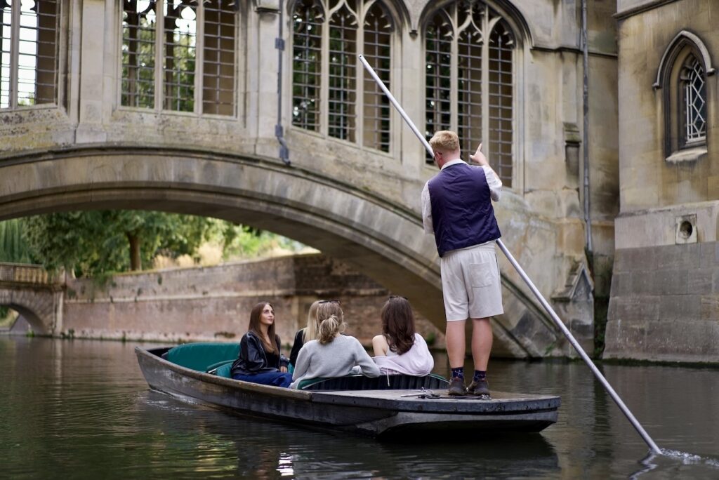 Chauffeur punting three passengers beneath the Bridge of Sighs at St John's College, Cambridge